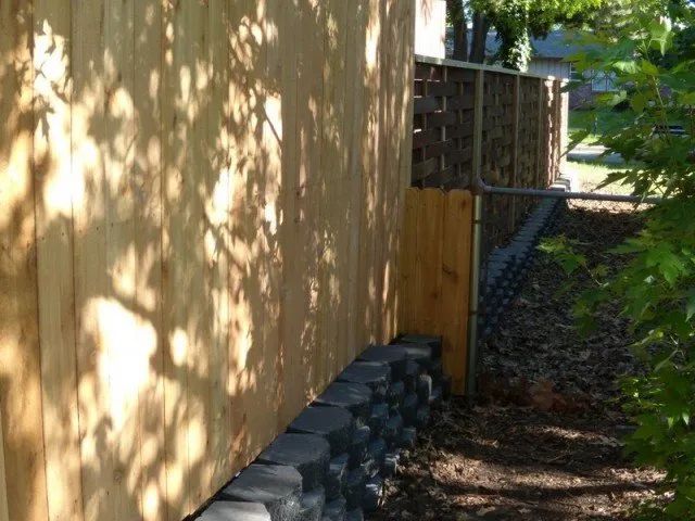 A wooden fence with a chain link fence behind it