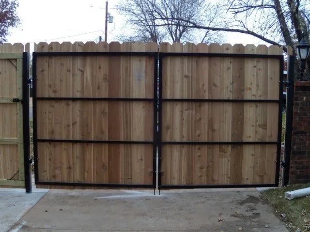 A wooden fence with a black metal frame