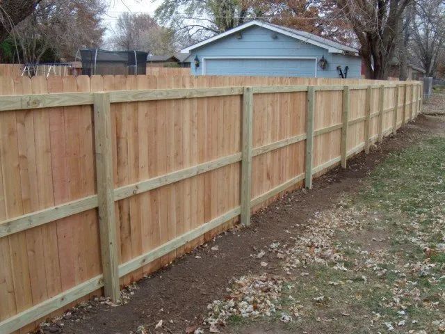 A wooden fence with a house in the background