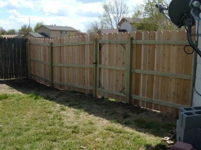 A wooden fence with a gate in the backyard
