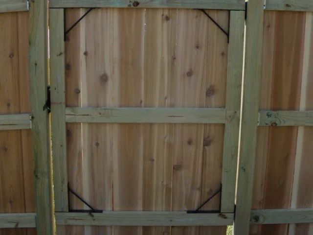 A close up of a wooden fence with a gate attached to it