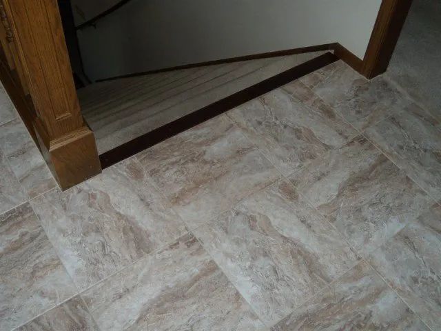A close up of a tiled floor next to a door in a room