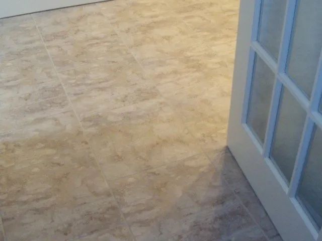 A white door is open to a tiled floor