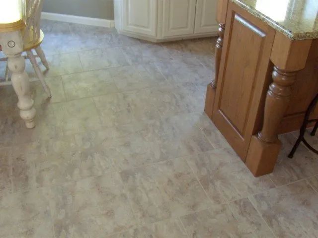 A kitchen with a table and chairs and a tiled floor
