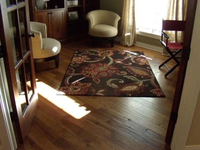 A living room with a chair and a rug on the floor