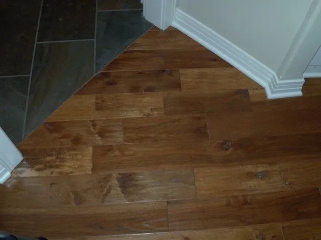 A wooden floor with a tile floor in the background