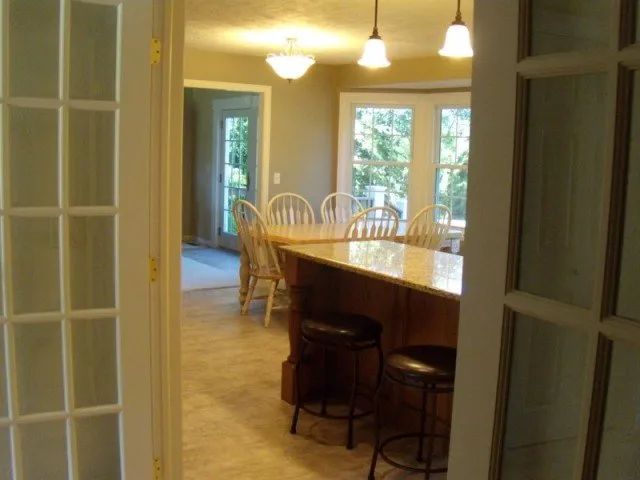 A kitchen with a table and chairs behind french doors