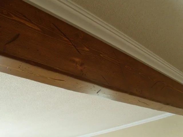 A wooden beam is hanging from the ceiling in a room