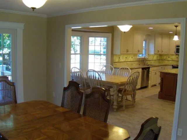 A dining room with a table and chairs and a kitchen