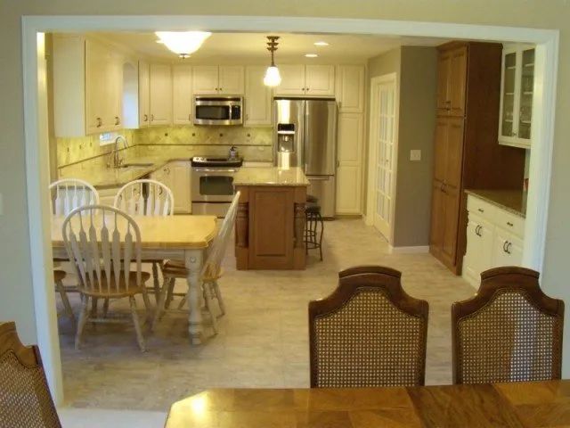 A kitchen with a table and chairs and a refrigerator