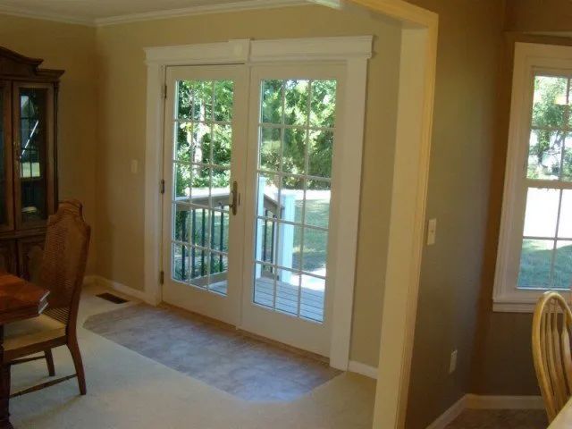 A dining room with a table and chairs and a sliding glass door