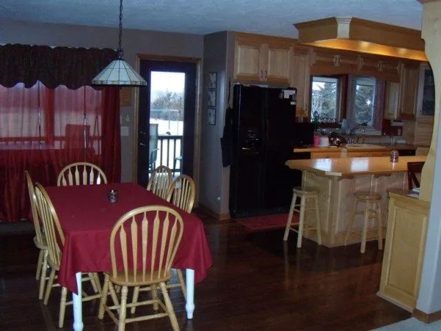 A dining room with a red table cloth and chairs
