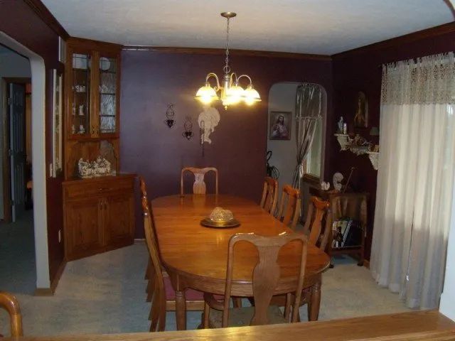 A dining room with a table and chairs and a chandelier