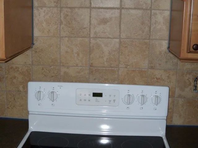 A white stove with a clock on the top of it