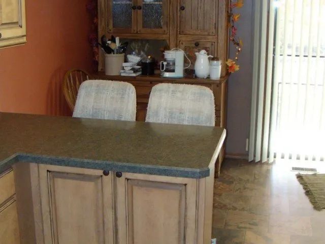 A kitchen with a table and chairs and a coffee maker