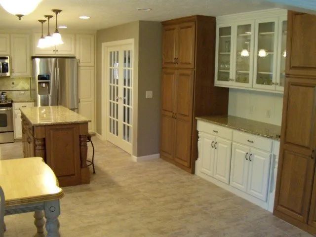 A kitchen with wooden cabinets and white counter tops