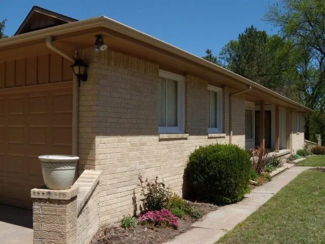 A brick house with a white pot in front of it