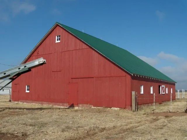 A large red barn with a green roof