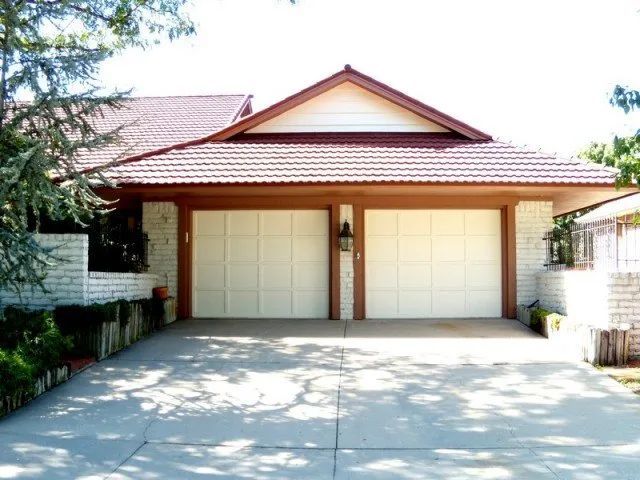 A house with two garage doors and a red roof