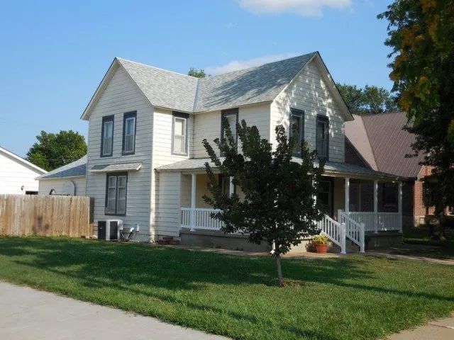 A white house with a tree in front of it