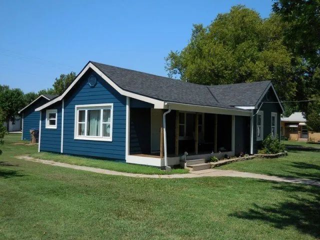 A blue house with white trim and a black roof