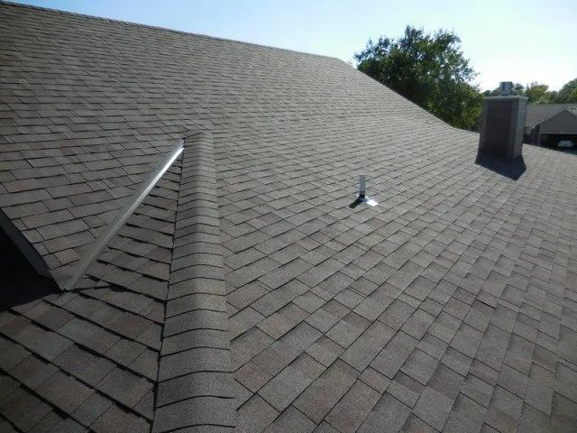 A roof with shingles and a chimney on it