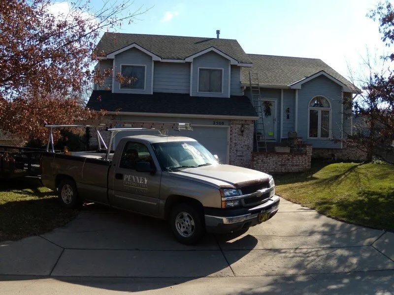A silver truck is parked in front of a house