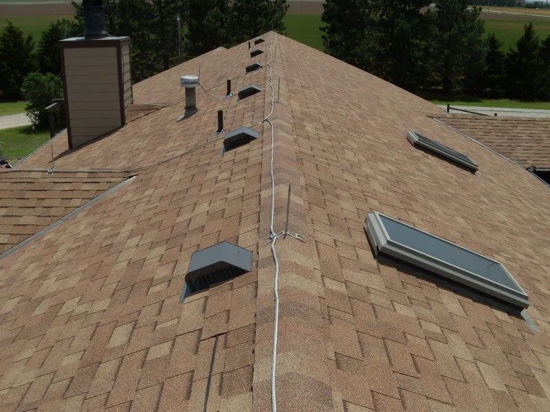 A roof with a chimney and skylights on it