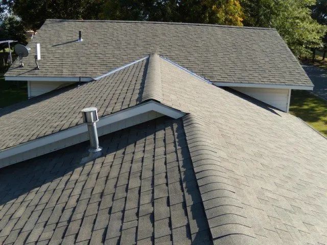 The roof of a house has a chimney on it
