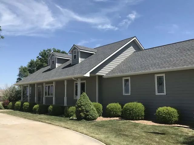 A large green house with a large porch