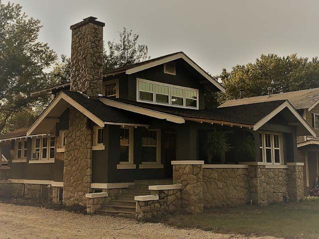 A house with a stone chimney and a lot of windows