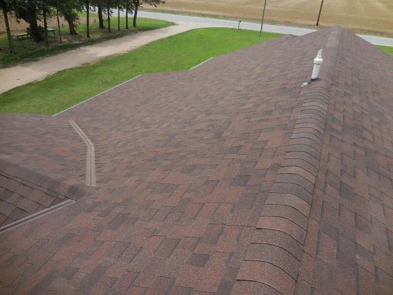 The roof of a house with a brown shingle roof