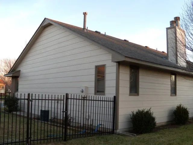 A white house with a black fence around it