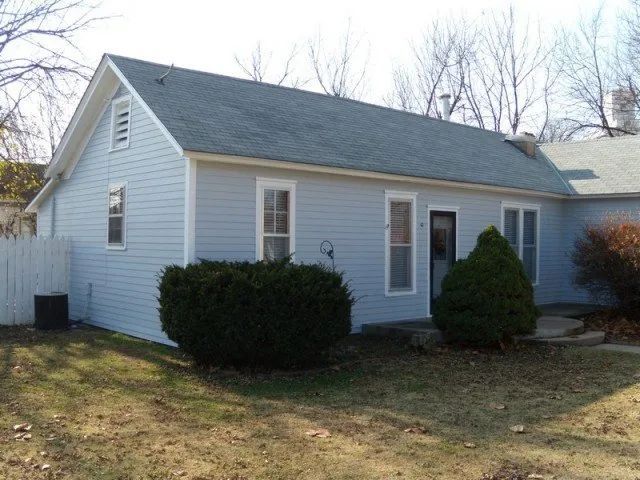 A small white house with a gray roof