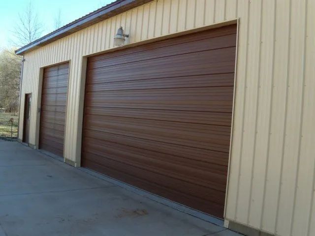 There are two garage doors on the side of a building