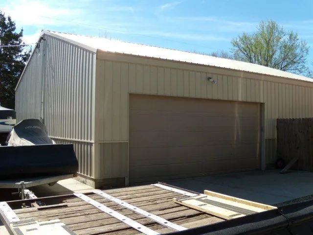 A garage with a boat in it and a ladder on top of it
