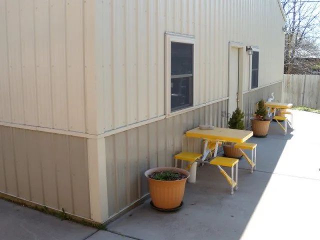 A white building with yellow tables and stools
