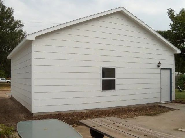 A white house with a picnic table in front of it