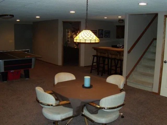 A basement with a table and chairs and a pool table