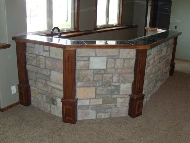A stone wall with a wooden counter top in a room