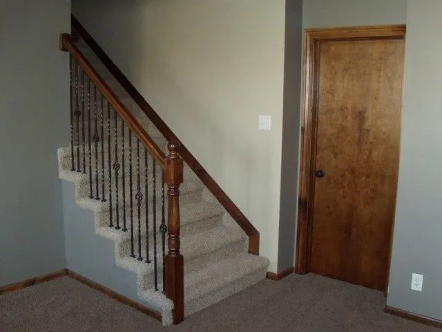 An empty room with stairs and a door