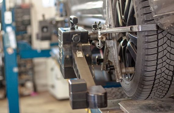 A car is being aligned with a machine in a garage.