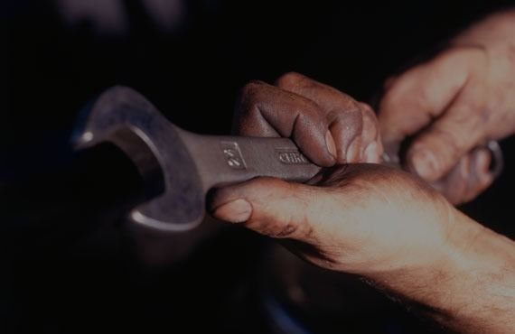 A person is holding a wrench with the number 22 on it