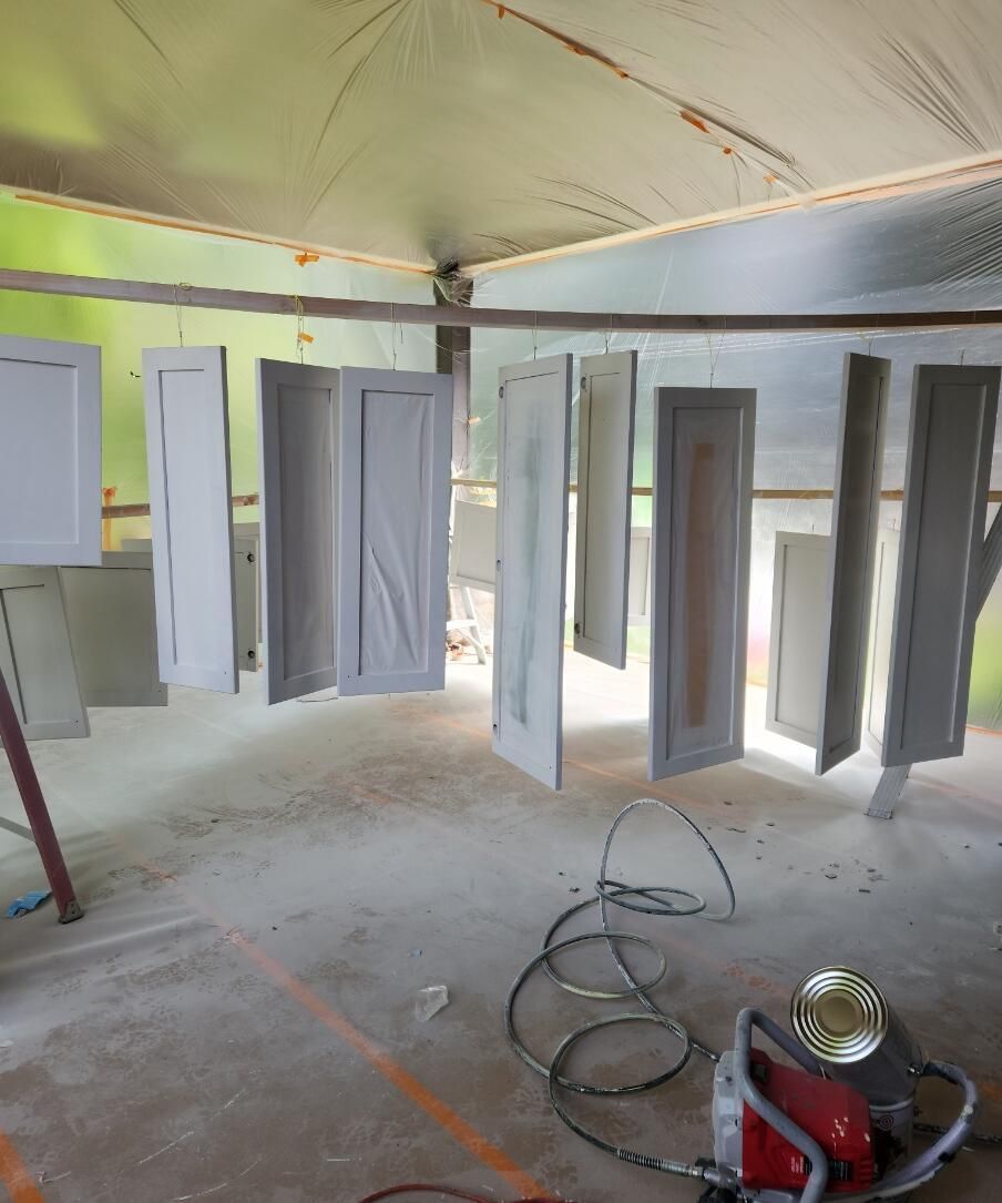 Interior of a room with hanging white doors or panels during renovation, with tools on the floor.
