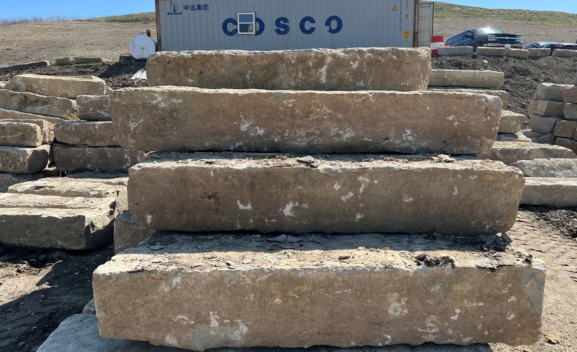 A stack of concrete blocks sitting on top of each other in a field.