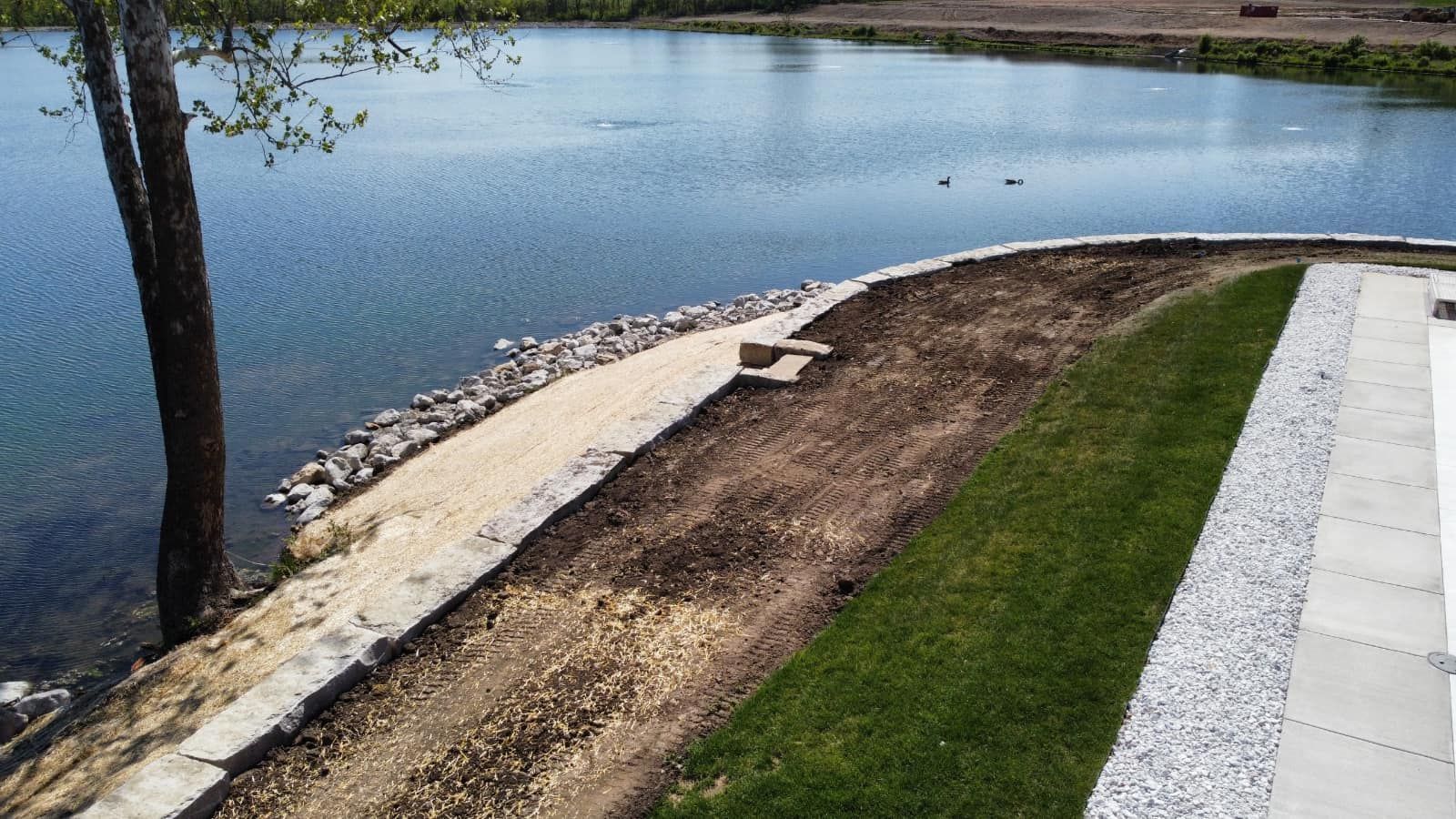 A concrete walkway is being built next to a lake.