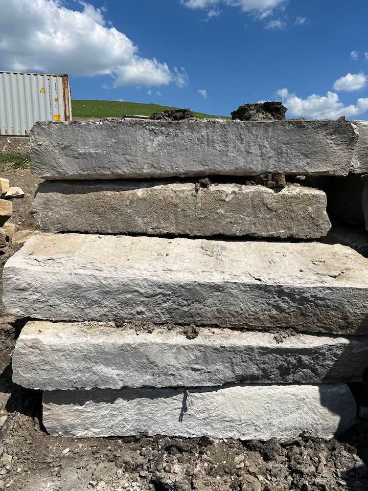 A pile of concrete blocks stacked on top of each other in a dirt field.