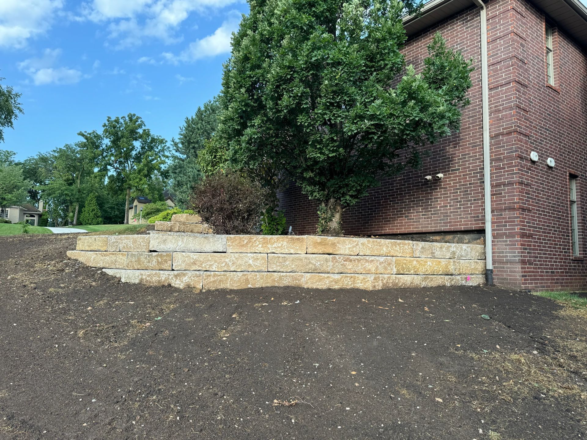 A brick house with a stone wall in front of it