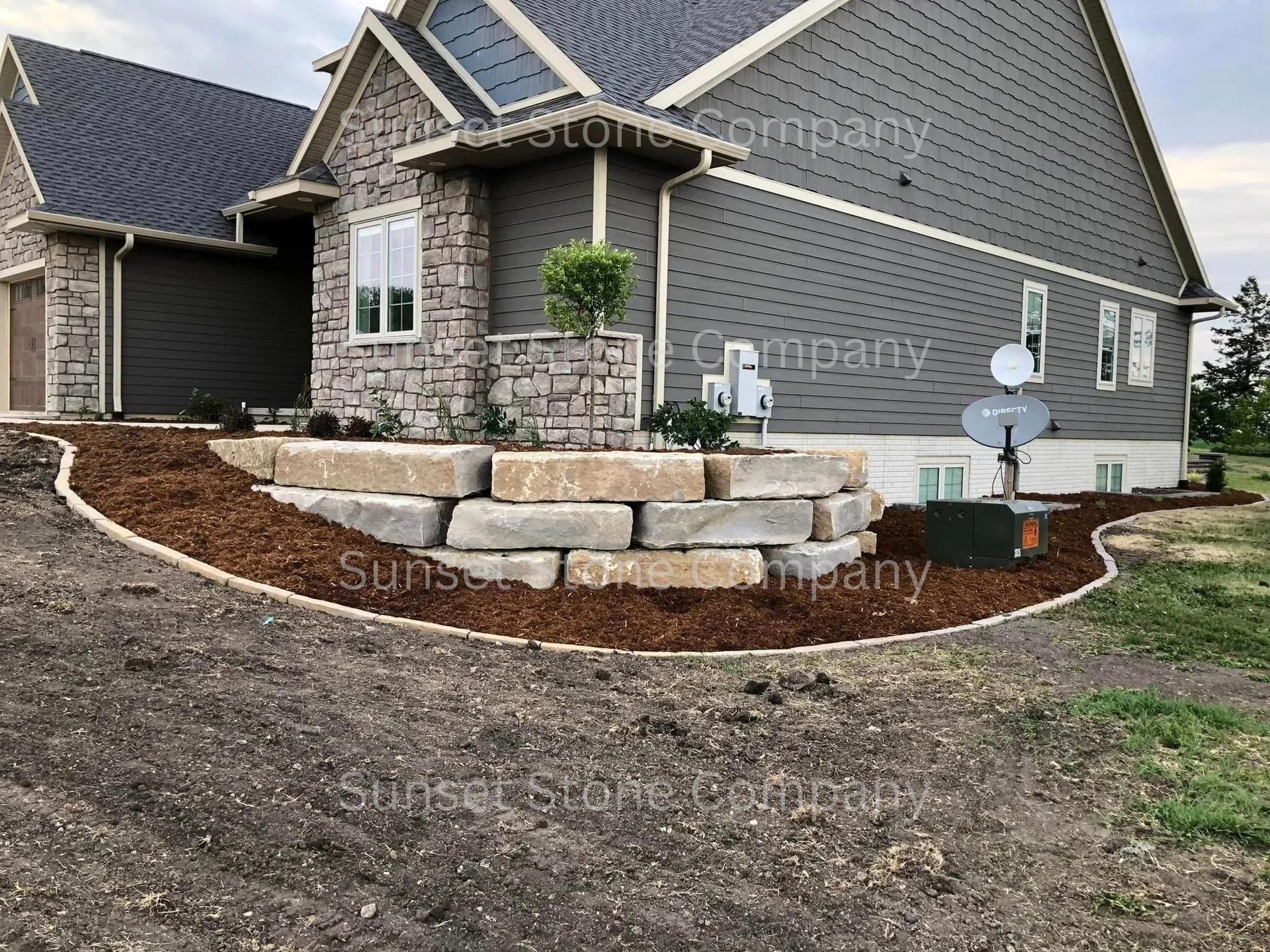 A large house with a stone wall in front of it