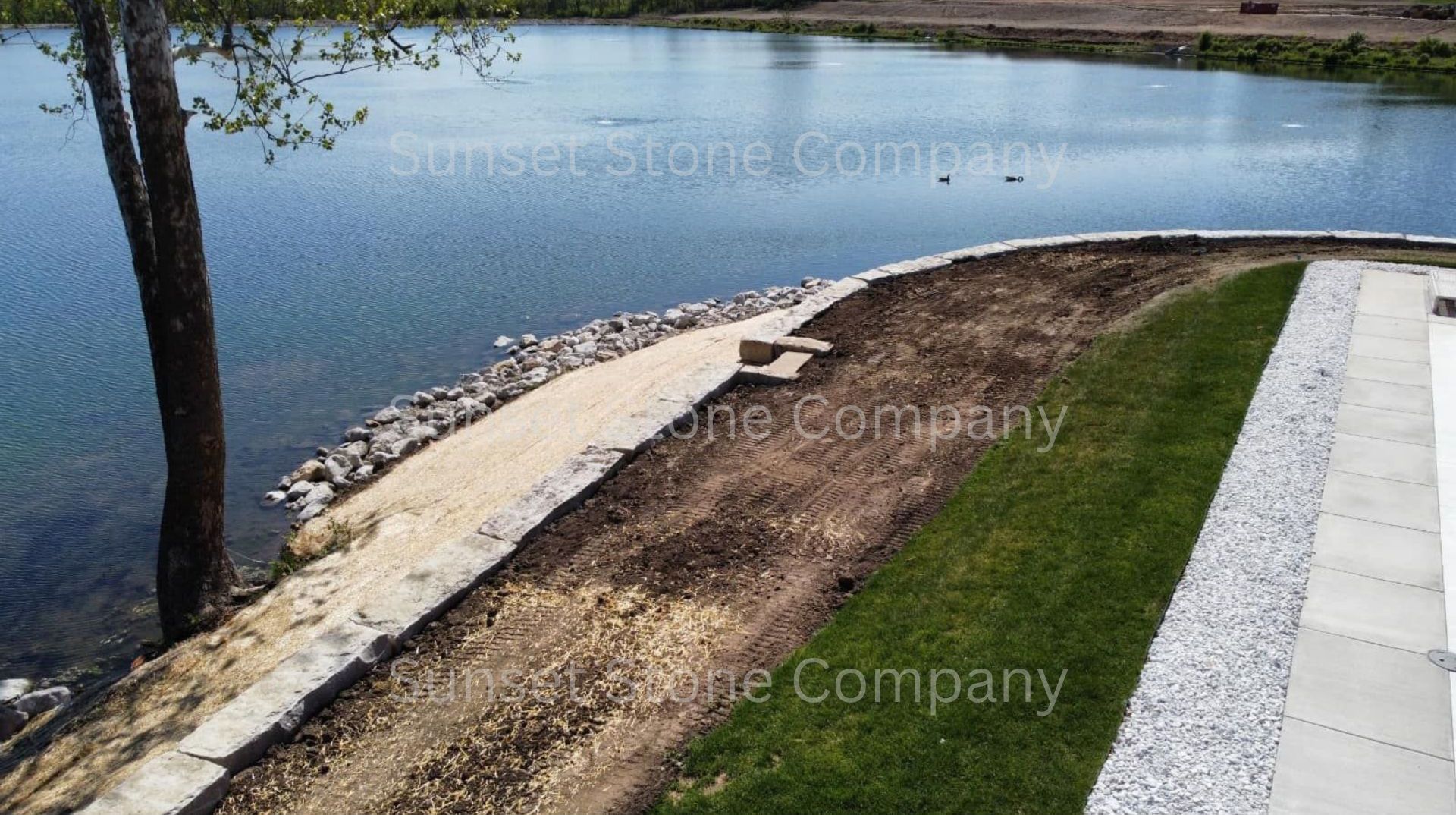 A concrete walkway is being built next to a body of water